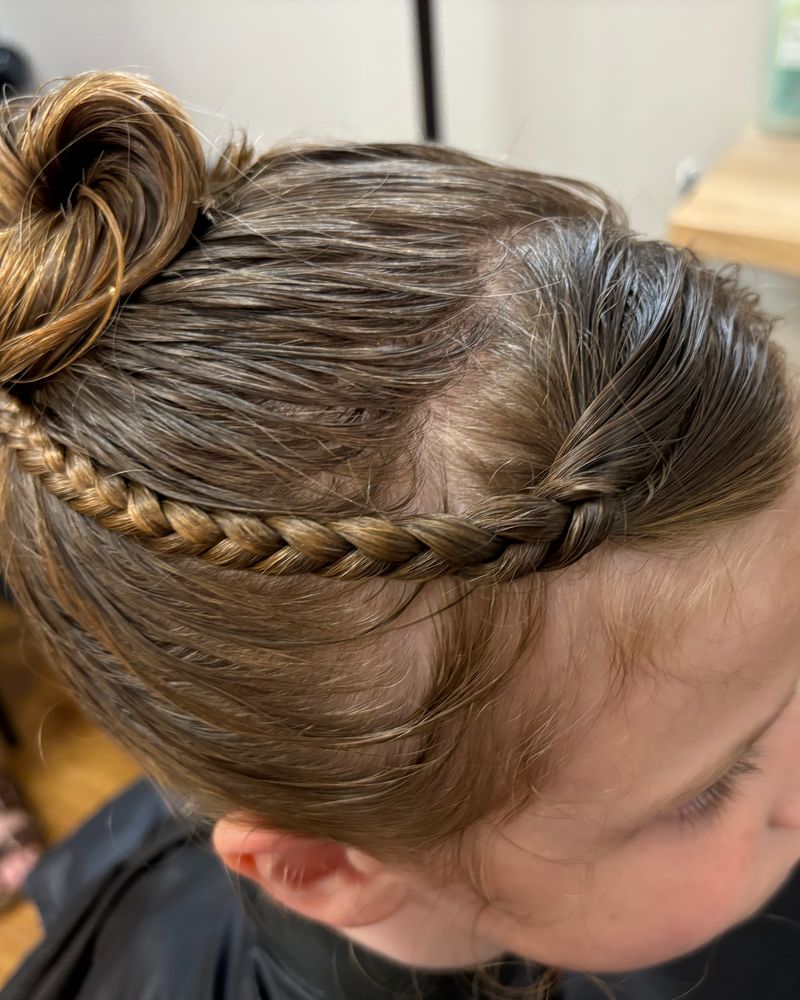 Child’s hair styled in a braid and top bun